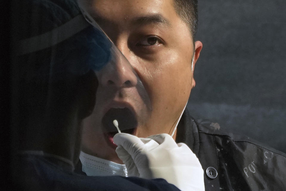 A man gets his routine COVID-19 throat swab at a coronavirus testing site in Beijing, Wednesday, Nov. 2, 2022. (AP Photo/Andy Wong)