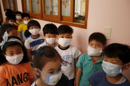 Elementary school students wearing masks to prevent contracting Middle East Respiratory Syndrome (MERS) wait in a line outside their classroom at an elementary school in Seoul, South Korea, June 9, 2015. REUTERS/Kim Hong-Ji