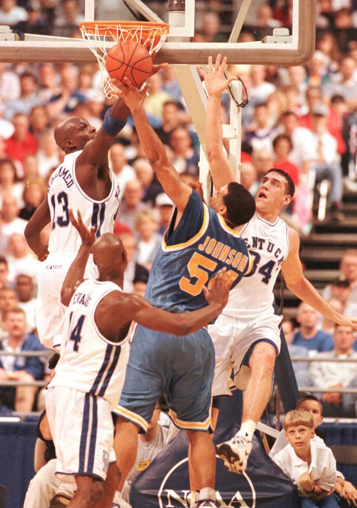 UK’s Nazr Mohammed blocks a shot by UCLA’s Kris Johnson, along with some help from Scott Padgett, right, and Heshimu Evans during the 1998 NCAA Tournament in St. Petersburg, Fla. Mohammed blocked six shots in the game.