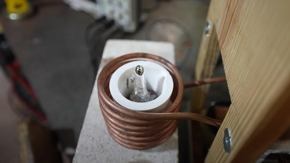 A dollop of boiling magnesium leaps from a ceramic boil being warmed by induction heating.