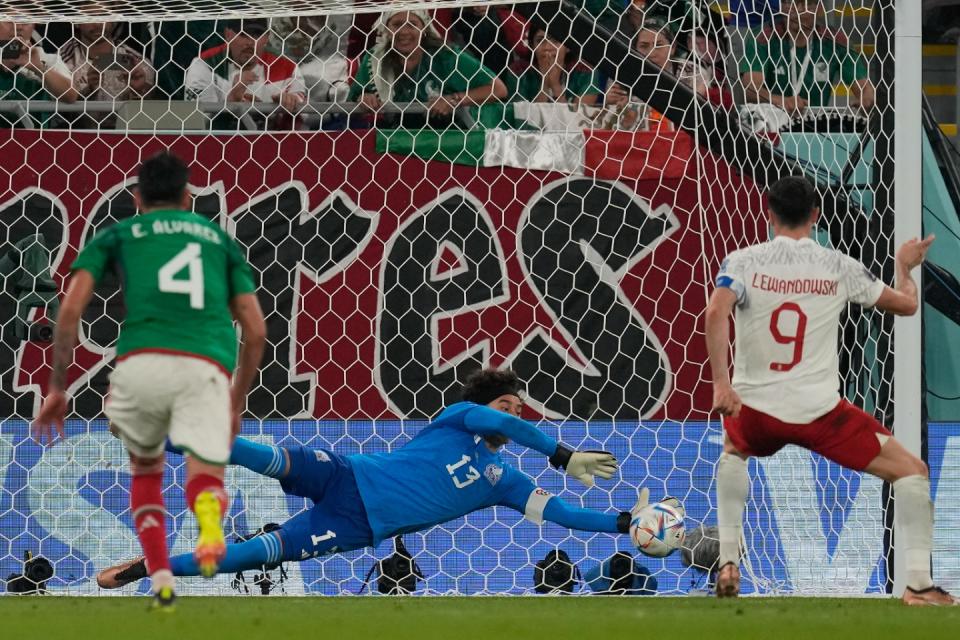 Mexico's goalkeeper Guillermo Ochoa saves a penalty kick by Poland's Robert Lewandowski during the World Cup group C football match between Mexico and Poland, at the Stadium 974 in Doha, Qatar, Tuesday, Nov. 22, 2022. (AP Photo/Themba Hadebe)