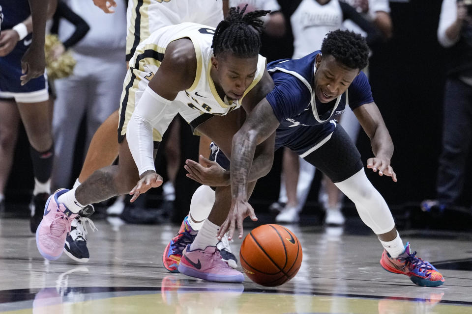 Purdue guard Lance Jones, left, an dSamford guard Josh Holloway (1) dive for a looss ball during the first half of an NCAA college basketball game in West Lafayette, Ind., Monday, Nov. 6, 2023. (AP Photo/Michael Conroy)