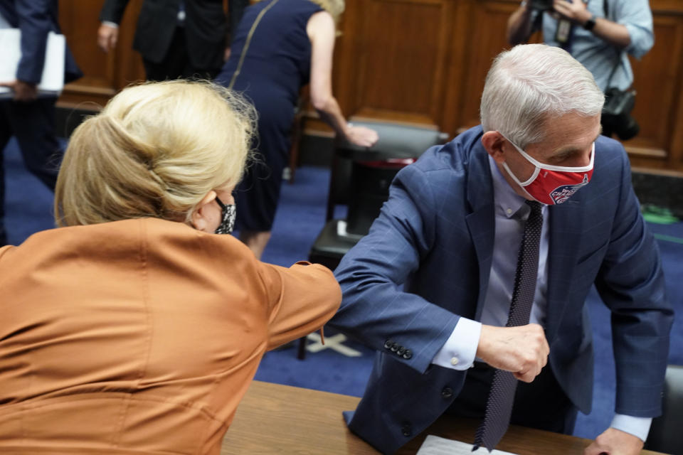 FILE - Dr. Anthony Fauci, director of the National Institute of Allergy and Infectious Diseases, right, and Rep. Carolyn Maloney, D-N.Y., wear protective masks while greeting each other with an elbow bump after a House Select Subcommittee hearing on the Coronavirus, July 31, 2020 on Capitol Hill in Washington. Fauci steps down from a five-decade career in public service at the end of the month, one shaped by the HIV pandemic early on and the COVID-19 pandemic at the end. (Erin Scott/Pool via AP, File)