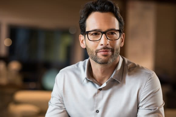 Young male adult in a collared shirt and glasses