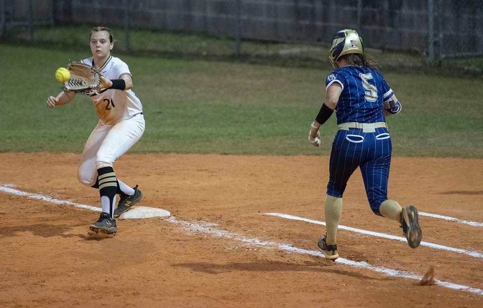 Milton High's Macee Graber makes the play as Gulf Breeze High's Isabel Rocha comes up short at first base during Thursday's District 1-5A softball tourney. 