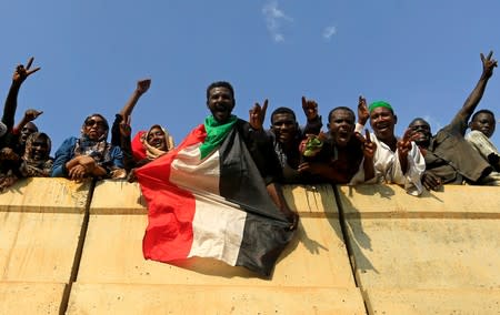 Civilians hold their national flag as they celebrate the signing of the Sudan's power sharing deal, in Khartoum