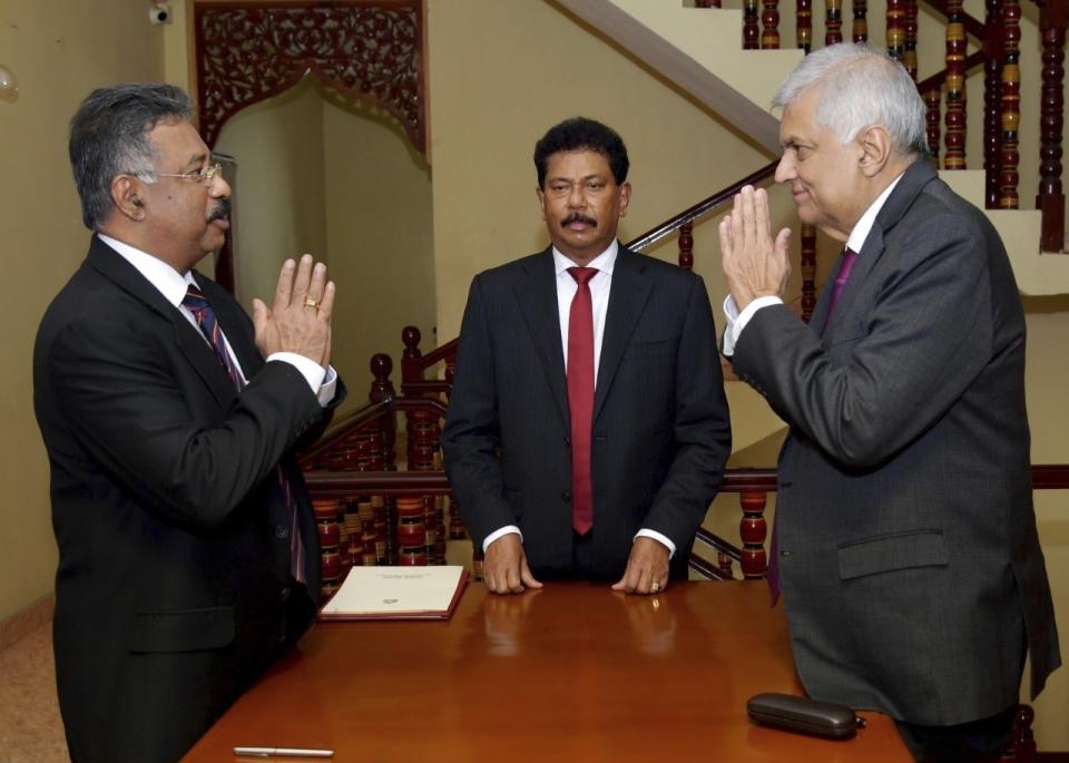 In this photograph provided by the Sri Lankan President's Office, interim President Ranil Wickremesinghe, right, greets Chief Justice Jayantha Jayasuriya during the oath-taking ceremony in Colombo, Sri Lanka, Friday, July 15, 2022. Prime Minister Wickremesinghe was sworn in as Sri Lanka's interim president Friday until Parliament elects a successor to Gotabaya Rajapaksa, who resigned after mass protests over the country's economic collapse forced him from office. (Sri Lankan President's Office via AP)