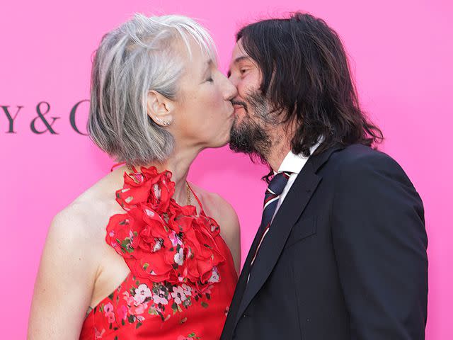 Momodu Mansaray/WireImage Alexandra Grant and Keanu Reeves share a kiss at the MOCA Gala in April 2023.