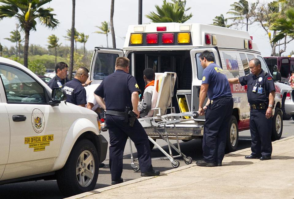 FILE - In this April 20, 2014 file photo, a 15-year-old boy, seen sitting on a stretcher center, who stowed away in the wheel well of a flight from San Jose, Calif., to Maui is loaded into an ambulance at Kahului Airport in Kahului, Maui, Hawaii. The teen’s mother, Ubah Mohamed Abdullahi, said while she spoke with Voice of America radio from a refugee camp in eastern Ethiopia, that her son had recently learned that she was alive after being told by his father she had died. (AP Photo/The Maui News, Chris Sugidono, File)