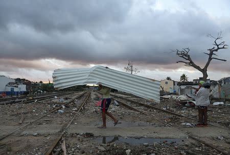 A man carries a sheet of aluminium after a tornado ripped through a neighbourhood in Havana, Cuba January 28, 2019. REUTERS/Fernando Medina