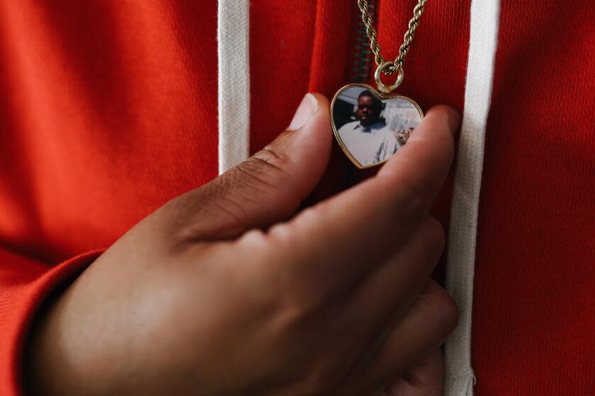 Lancaster, CA - January 07: Tawana Hunter holds a necklace with her father's photograph inside at home on Sunday, Jan. 7, 2024 in Lancaster, CA. Her father, Jucal Hunter, died in jail. (Dania Maxwell / Los Angeles Times)