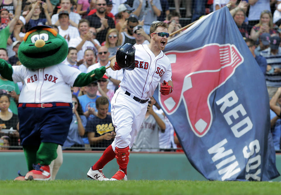BOSTON - AUGUST 22: After he knocked in the game winning run with a bottom of the tenth inning RBI single, Boston Red Sox second baseman Brock Holt celebrates with team mascot Wally the Green Monster at left. The Boston Red Sox host the Kansas City Royals in the conclusion of a regular season MLB baseball game that was suspended by weather in the top of the tenth inning earlier in the month at Fenway Park in Boston on Aug. 22, 2019. (Photo by Jim Davis/The Boston Globe via Getty Images)