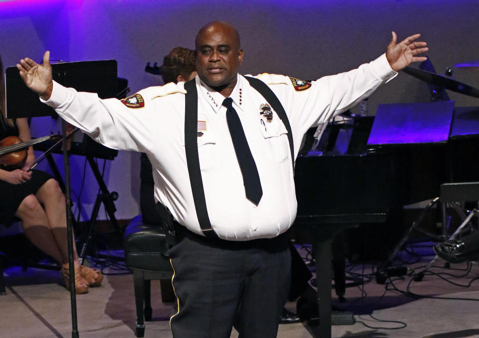 Brookhaven Police Chief Kenneth Collins calls on all lawmen and women to stand and be acknowledged as "family"during funeral services Thursday, Oct. 4, 2018, for Brookhaven Police Corporal Zach Moak at Easthaven Baptist Church in Brookhaven, Miss. Moak and officer James White were killed early Saturday, Sept. 30, responding to a call. (AP Photo/Rogelio V. Solis)
