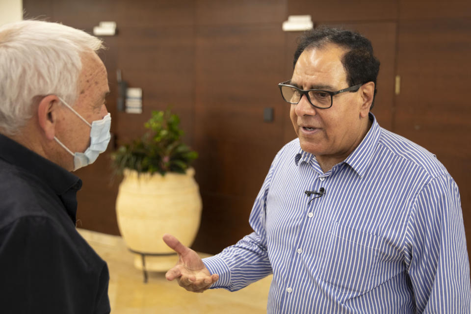 Dr. Izzeldin Abuelaish speaks with Israeli Minister of Agriculture Alon Shuster at the Knesset, Israel's parliament in Jerusalem, Wednesday, Nov. 10, 2021. For 13 years, the man known in Israel as "the Gaza doctor" has waged a battle through the Israeli courts and the public to remember and deliver justice to his daughters Aya, 13, Bessan, 21, Mayar, 15, and his niece Noor, 17, all killed by an Israeli missile in their bedroom on January 16, 2009. On Monday, Nov. 15, Israel's Supreme Court will hear Abuelaish's demand for an apology and compensation. (AP Photo/Sebastian Scheiner)