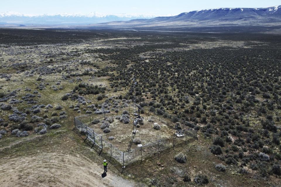 An employee stands near the Lithium Nevada Corp. mine site at Thacker Pass on April 24, 2023, near Orovada, Nev. The huge lithium mine under construction is at the center of a dispute over President Joe Biden's clean energy agenda. (AP Photo/Rick Bowmer)