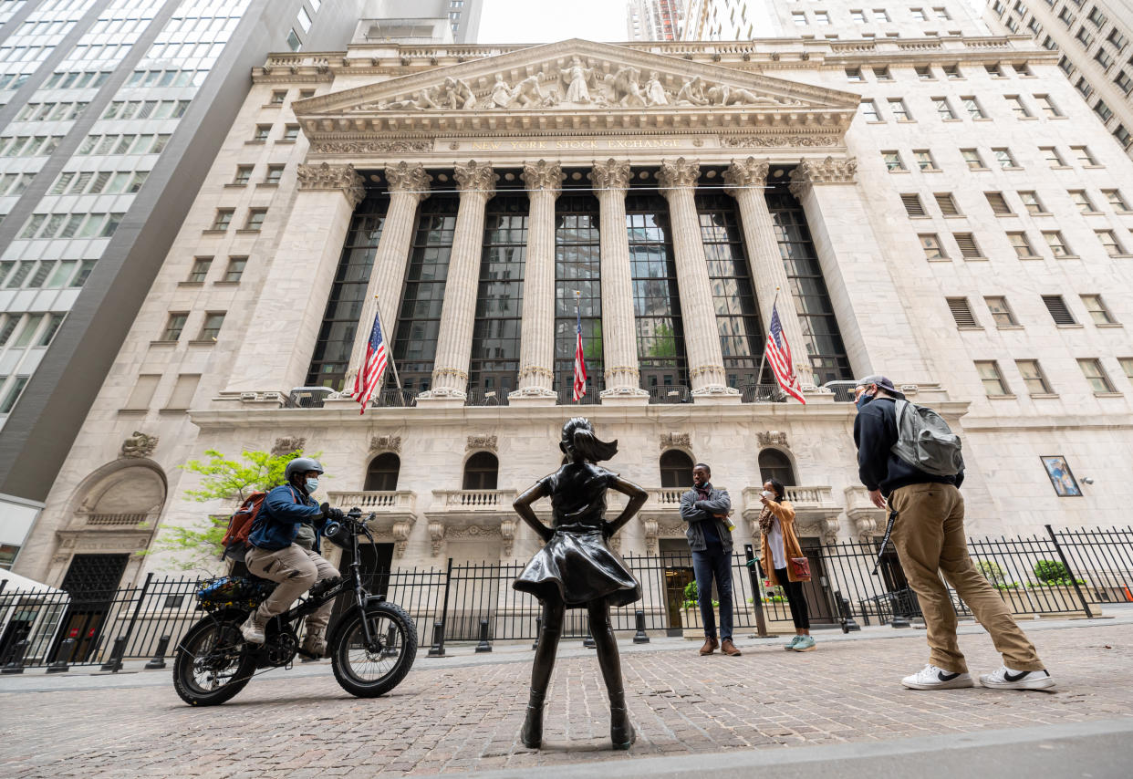 NEW YORK, NEW YORK - MAY 11: People visit the Fearless Girl Statue in front of the New York Stock Exchange in Wall Street on May 11, 2021 in New York City. New York Governor Andrew Cuomo announced pandemic restrictions to be lifted on May 19.  (Photo by Noam Galai/Getty Images)