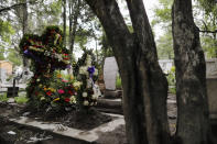 FILE - In this July 27, 2020 file photo, crosses of fresh flowers adorn a new grave at Xilotepec Cemetery amid the new coronavirus pandemic, in Xochimilco, Mexico City. From April 19 to June 30, the capital city saw over 17,800 more deaths than usual. (AP Photo/Rebecca Blackwell, File)