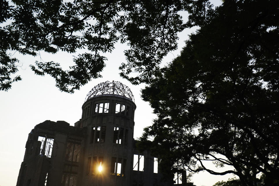 FILE - In this Aug. 2, 2020, file photo, the Atomic Bomb Dome is seen at dusk in Hiroshima, western Japan. Many residents of Hiroshima welcome attention to their city from abroad, which IOC President Thomas Bach will bring when he visits on Friday, July 16. But Bach will also bring political baggage — as will his vice president John Coates when he visits Nagasaki the same day — that is largely unwelcome in two cities viewed as sacred by many Japanese.(AP Photo/Eugene Hoshiko, File)