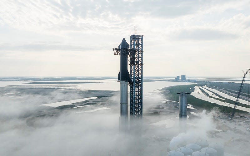 SpaceX Super Heavy first-stage booster with the black side of its Starship second stage booster showing.