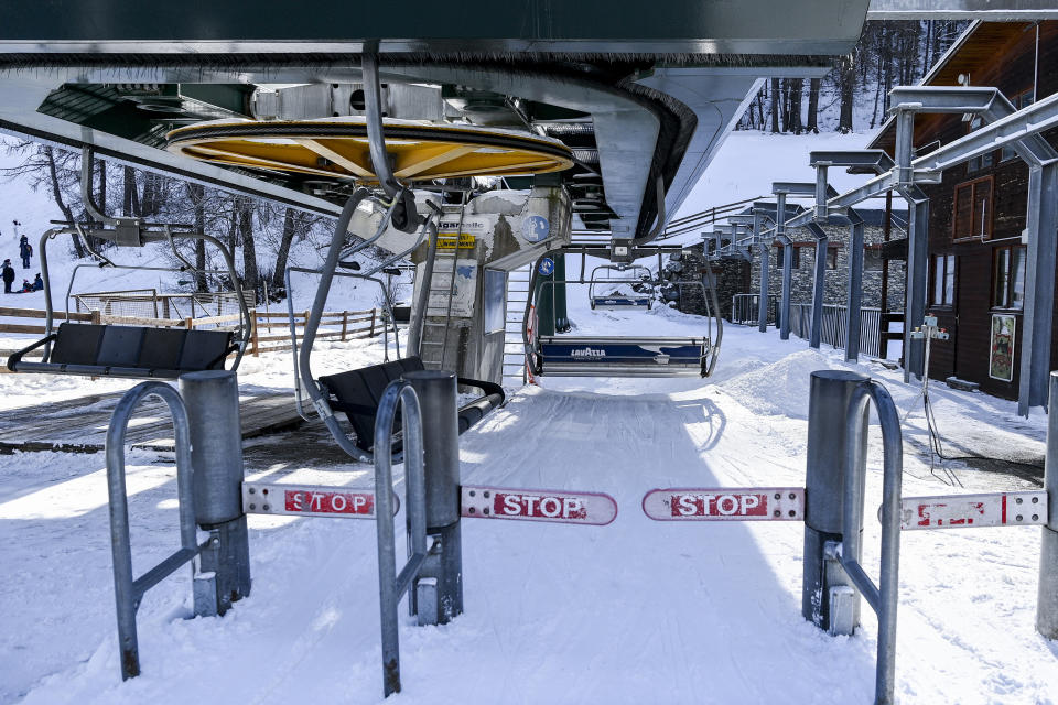 The access to the chair lift area in Bardonecchia, northern Italy, is deserted, Monday, Feb. 15, 2021, after the Italian government on Sunday abruptly delayed opening Italy's beloved ski season because a coronavirus variant was detected in a good portion of recently infected persons in the country. (Marco Alpozzi/LaPresse via AP)