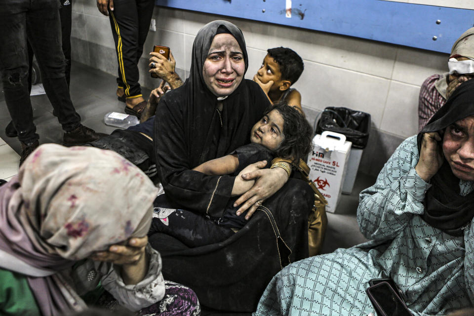 Wounded Palestinians sit in al-Shifa hospital in Gaza City, central Gaza Strip, after arriving from al-Ahli hospital following an explosion there, Tuesday, Oct. 17, 2023. The Hamas-run Health Ministry says an Israeli airstrike caused the explosion that killed hundreds at al-Ahli, but the Israeli military says it was a misfired Palestinian rocket. (AP Photo/Abed Khaled)