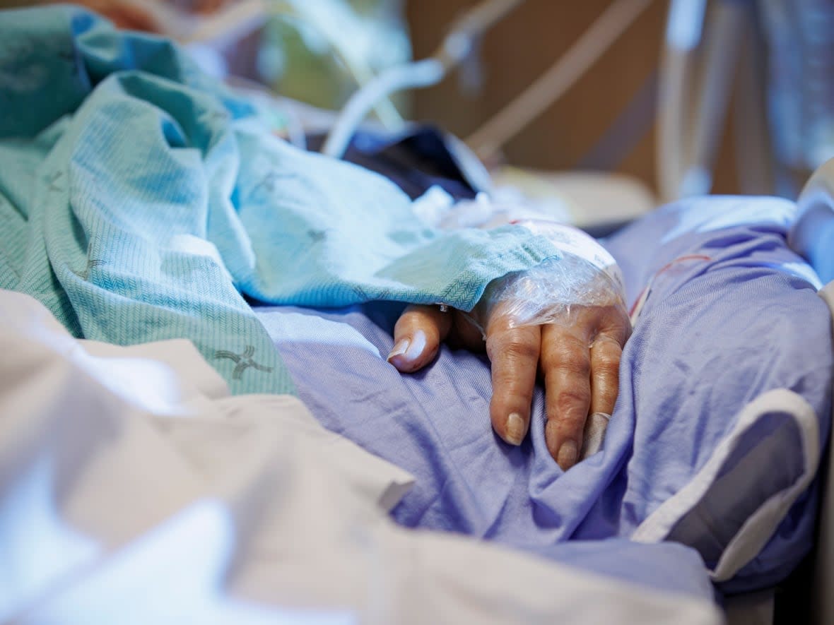 The hand of a COVID-19 patient on a ventilator is pictured in the intensive care unit of Humber River Hospital, in Toronto, on Jan. 25 Thursday's reported hospitalizations are down slightly from 1,082 on Wednesday and 1,207 exactly one week ago. (Evan Mitsui/CBC - image credit)