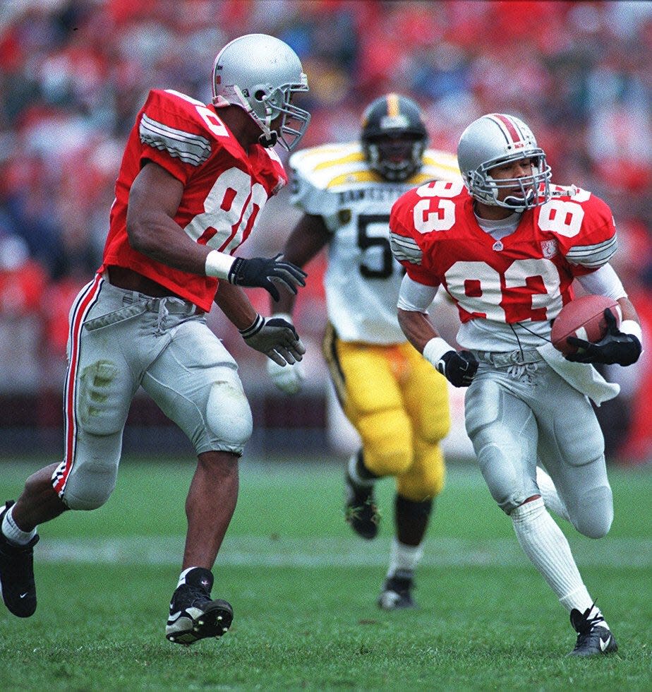 OSU's Terry Glenn is accompanied by Rickey Dudley on his way to a TD after a completion in the first half to make it 27-0 against Iowa. Russell Photo