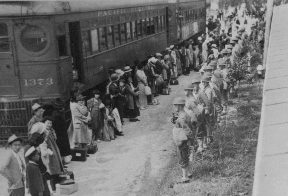 Japanese Americans gather at a train that will take them from the Santa Anita assembly camp in California to be detained at a camp at Gila River, Ariz., in 1942.