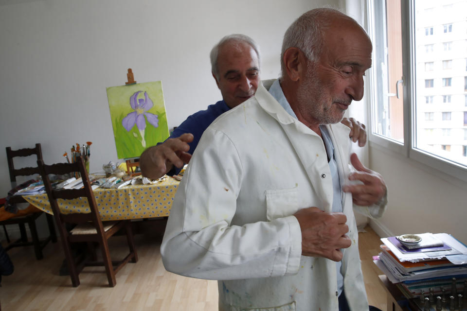 In this photo taken on Friday June 5, 2020, Gilbert Haiun jokes with his brother Dr Robert Haiun, in Ivry sur Seine, south of Paris. Families whose elders died behind the closed doors of homes in lockdown are filing wrongful death lawsuits, triggering police investigations. One suit focuses on the death of Meyer Haiun, a severely disabled 85-year-old in a Paris home managed by a Jewish charitable foundation headed Eric de Rothschild, scion of Europe's most famous banking dynasty. (AP Photo/Francois Mori)