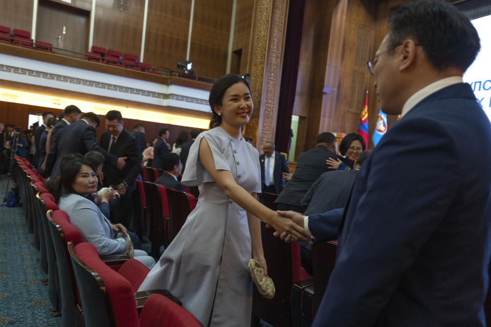 Tsenguun Saruulsaikhan, a young and newly minted member of Mongolia's parliament, shakes hands with colleagues before receiving her Parliament membership card at a ceremony held at the Government Palace in Ulaanbaatar, Mongolia, Monday, July 1, 2024. Tsenguun was one of 42 winning candidates from the Democratic Party, the main opposition group, which made a major comeback after being reduced to a handful of seats in the 2016 and 2020 elections. (AP Photo/Ng Han Guan)