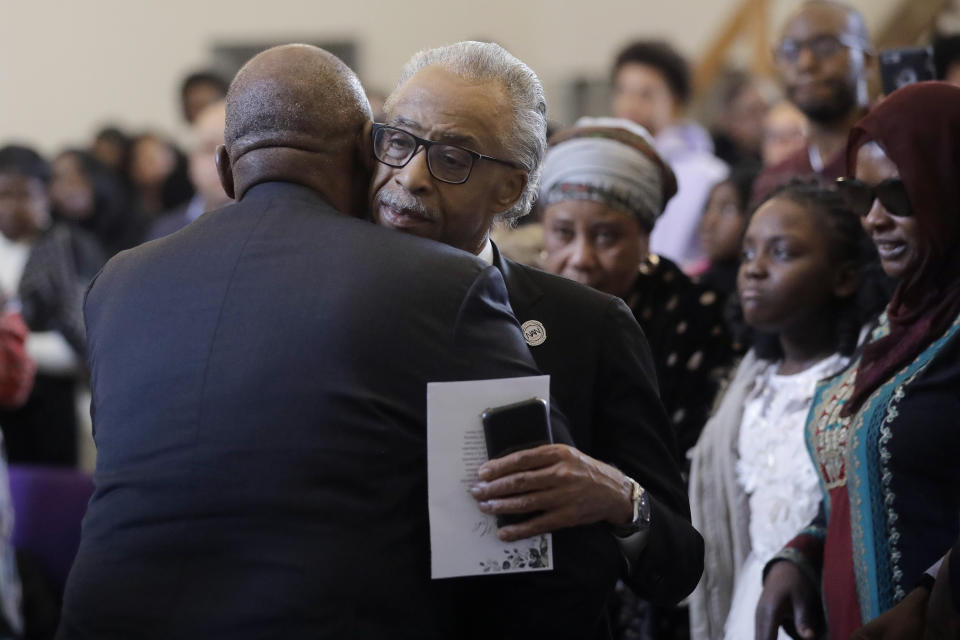The Rev. Al Sharpton, center, civil rights activist and founder of the National Action Network, hugs Suhnoon Adams, left, great uncle of 19-year-old fatal shooting victim Mubarak Soulemane, as Soulemane's mother Omo Muhammed, right, looks on Sunday, Jan. 26, 2020, during ceremonies to honor Mubarak's life, at the First Calvary Baptist Church, in New Haven, Conn. The Jan. 15, 2020 shooting by a Connecticut State Police trooper took Soulemane's life following a high-speed car chase, in West Haven, Conn. (AP Photo/Steven Senne)