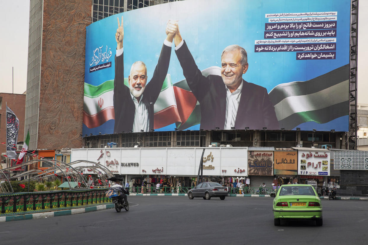 The large picture of Ismail Haniyeh and Masoud Pezeshkian, the new and reformist president of Iran, which was taken at the inauguration ceremony, has been installed in Valiasr Square in Tehran. Haniyeh, who had lived in Qatar, was killed in an airstrike in Tehran after attending the inauguration of Iran's new president. His body is due to return to Qatar for an official funeral and burial tomorrow.  (Majid Saeedi / Getty Images)