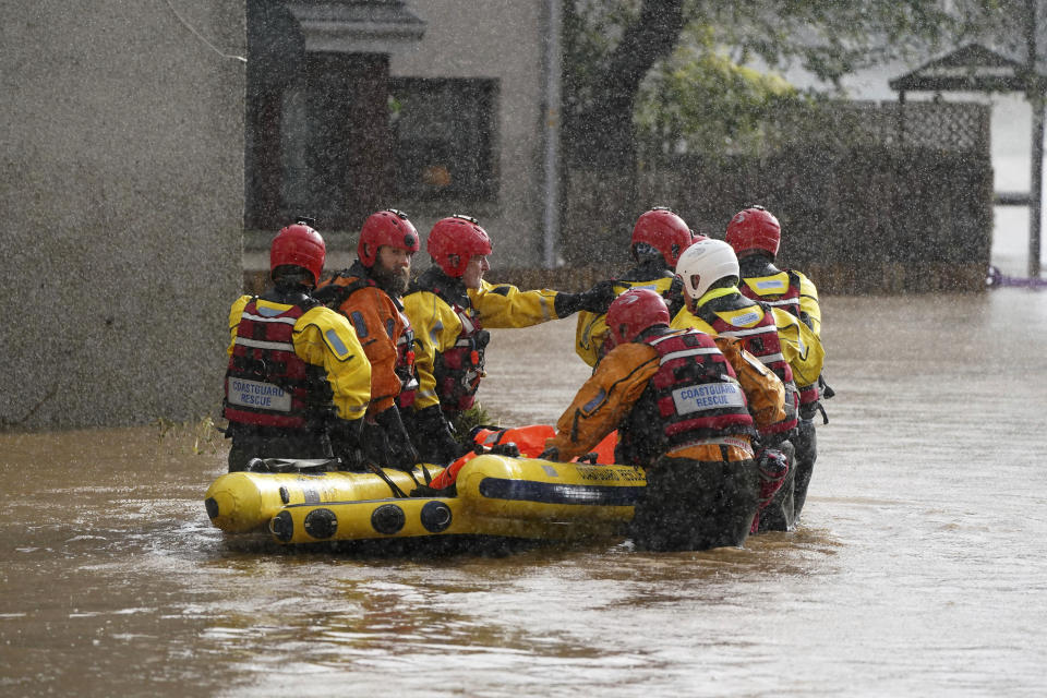 Members of the emergency services help local residents to safety as Storm Babet batters the country in Brechin, Scotland, Friday Oct. 20, 2023. Flood warnings are in place in Scotland, as well as parts of northern England and the Midlands. (Andrew Milligan/PA via AP)