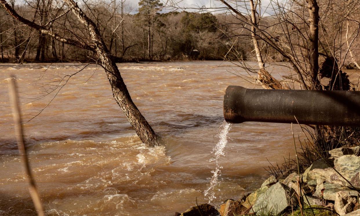 <span>A pipe discharges water into the Haw River near Bynum, North Carolina.</span><span>Photograph: Jeremy M Lange/The Guardian</span>