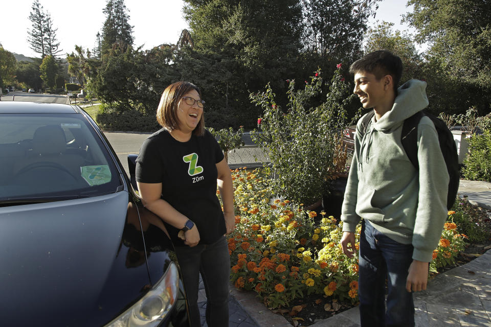 In this photo taken Tuesday, Oct. 29, 2019, Zum driver Stacey Patrick, left, speaks to student Saahas Kohli after driving him home from school in Saratoga, Calif. A handful of ride-hailing companies have surfaced that allow parents to order rides, and in some cases childcare, for children using smartphone apps. The promise is alluring at a time when children are expected to accomplish a dizzying array of extracurricular activities and the boundaries between work and home have blurred. But the companies face hurdles convincing parents that a stranger hired by a ride-hailing company is trustworthy enough to ferry their most precious passengers. (AP Photo/Ben Margot)
