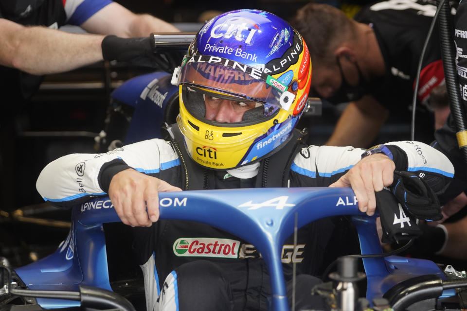 Alpine driver Fernando Alonso, of Spain, climbs into his car during a practice session for the F1 US Grand Prix auto race at the Circuit of the Americas, Friday, Oct. 22, 2021, in Austin, Texas. (AP Photo/Darron Cummings)