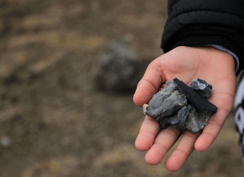 A man holds shrapnel from a missile launched by Iran on U.S.-led coalition forces on the outskirts of Duhok