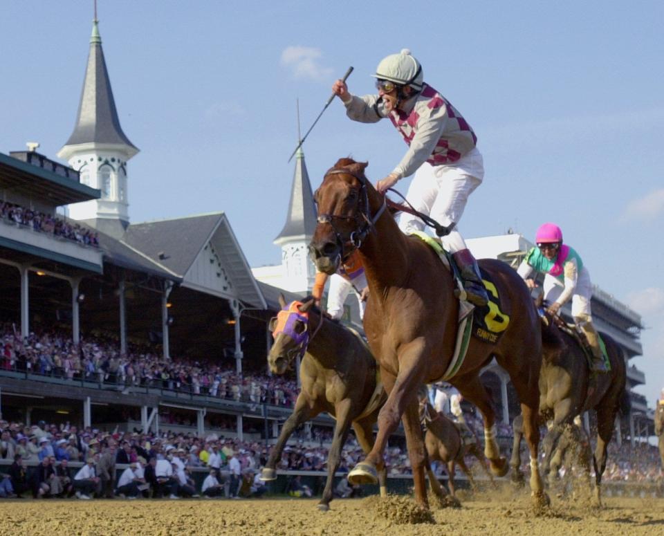 Jockey Jose Santos celebrates aboard Funny Cide after crossing the finish line to win the 129th running of the Kentucky Derby at Churchill Downs, in this May 3, 2003 file photo.