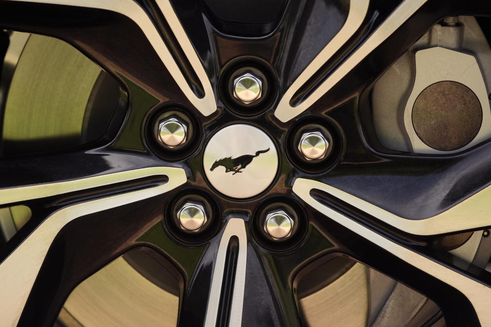 A Ford Mustang Mach-E logo is seen of a vehicle's wheel, Thursday, May 9, 2024, in San Antonio. Many Americans still aren’t sold on going electric for their next car purchase. High prices and a lack of easy-to-find charging stations are major sticking points, a new poll shows. (AP Photo/Eric Gay)