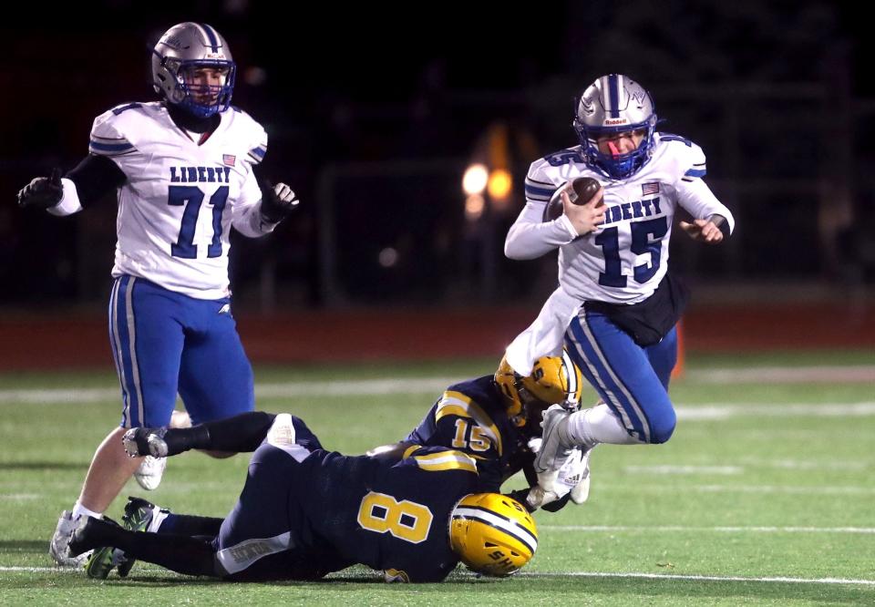 Springfield's Jaivian Norman (8) and Jackson Heims (15) trip up Olentangy Liberty's Andrew Leonard during an OHSAA Division I Regional Final game Nov. 18 at London High School.