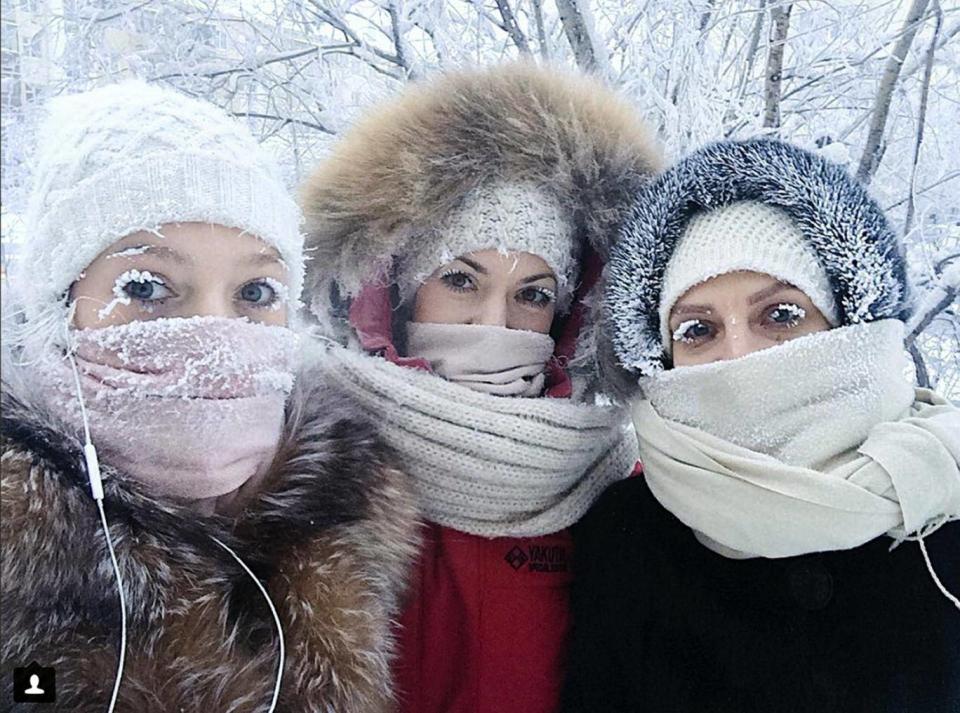 Anastasia Gruzdeva, left, poses for selfie with her friends as the temperature dropped below -50 degrees in Yakutsk, Russia (AP)