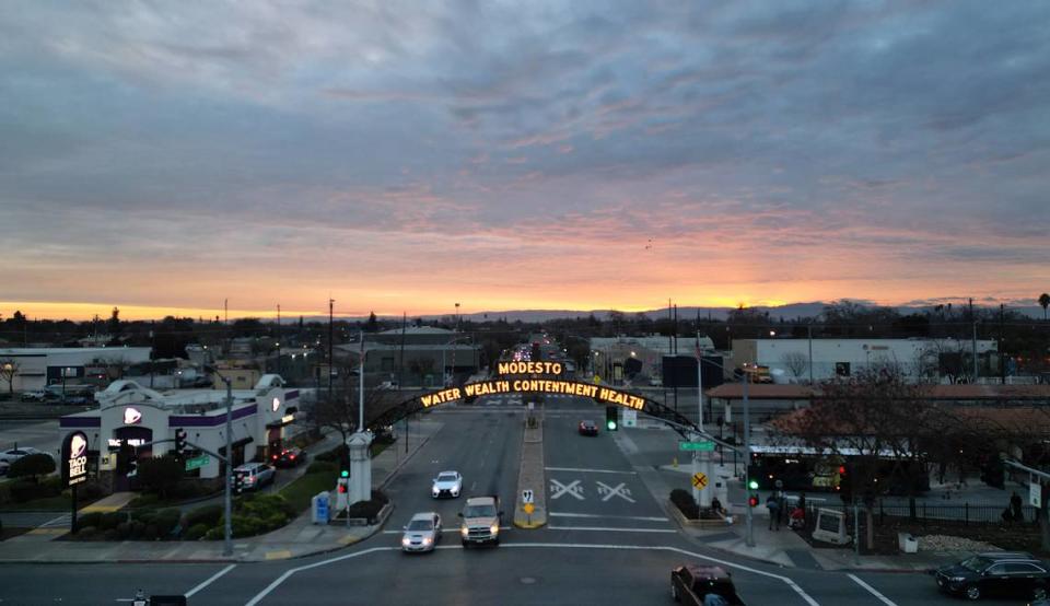 El sol se pone tras la cordillera del Diablo y el Arco de Modesto en Modesto, California, el 12 de enero de 2024.