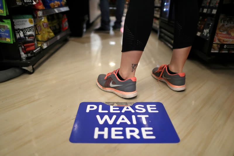 Social distancing decals are seen on the floor of Ralphs Kroger grocery store after California issued a stay-at-home order in an effort to prevent the spread of coronavirus disease (COVID-19), in Los Angeles