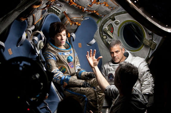 Sandra Bullock, George Clooney and director Alfonso Cuarón on the set of the dramatic thriller "Gravity."