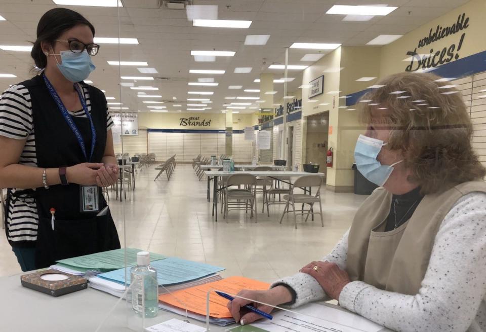 Volunteer Elaine Brady, of the Sanford-Springvale Altrusa Club, chats with Caitlin Lipert, of the York County Emergency Management Agency, at the vaccine clinic at The Center for Shopping in Sanford on Tuesday, Jan. 18, 2022.