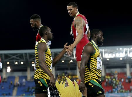 Ryan Bailey of the U.S. (top R) shakes hands with Jamaica's Usain Bolt (L) on the medals podium after the U.S. won the 4x100 meters race at the IAAF World Relays Championships in Nassau, Bahamas May 2, 2015. Jamaica placed second and Japan third. REUTERS/Mike Segar