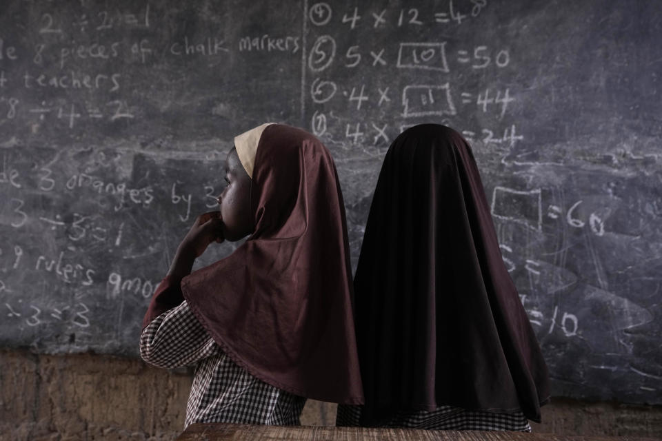 Students of Excellent Moral School attempt to answer a mathematics question on a blackboard inside a dimly lit classroom in Ibadan, Nigeria, Tuesday, May 28, 2024. Schools like Excellent Moral operate in darkness due to zero grid access, depriving students of essential tools like computers. (AP Photo/Sunday Alamba)