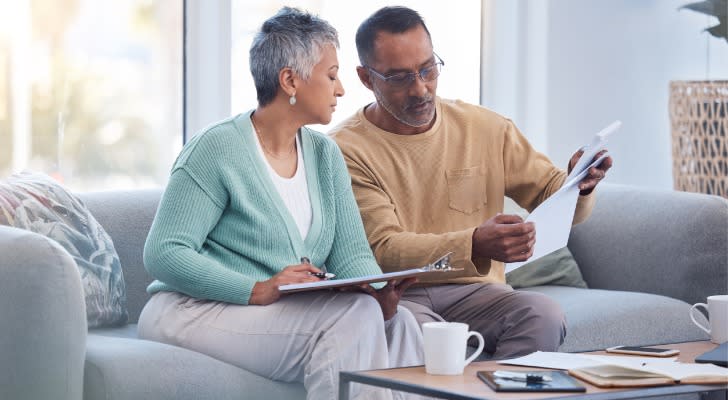 A couple looks over their finances as they decide whether to get an annuity or invest in a target date fund. 