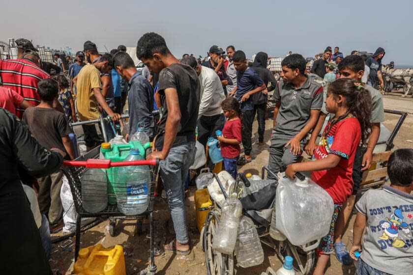 DEIR AL BALAH, GAZA - MAY 20: Palestinians who were forced to migrate to the central town of Deir al-Balah to protect themselves from the attacks on Gaza by Israel and ensure their safety, form queues to receive clean water distributed by aid organizations in Gaza on May 20, 2024. (Photo by Abed Rahim Khatib/Anadolu via Getty Images)