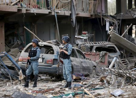 Afghan policemen stand guard at the site of a suicide truck bomb in Kabul, Afghanistan August 7, 2015. REUTERS/Omar Sobhani